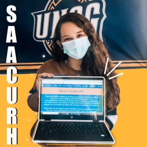 Student holding up a laptop with information about SAACURH